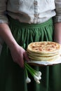 Woman holding in her hands traditional in different countries pies stuffed with cheese and herbs and fresh garlic.