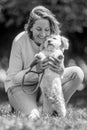 A Woman holding her little dog up in the park at a dog show