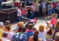 Woman holding her shoes and bending over backwards to dance under a limbo bar surrounded by people in tropicl clothing at party in Royalty Free Stock Photo