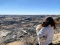 A woman holding her small dog admiring a beautiful panoramic view of the badlands in Dinosaur provincial park, Alberta, Canada. Royalty Free Stock Photo