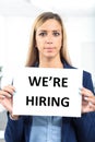 Woman holding hiring sign in a worklace bacground