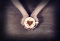 Woman holding hot cup of coffee, with heart shape Royalty Free Stock Photo