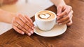 Woman holding hot cup of coffee, with heart shape Royalty Free Stock Photo