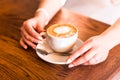 Woman holding hot cup of coffee, with heart shape Royalty Free Stock Photo