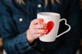 Woman holding cup with heart shape. Close up Royalty Free Stock Photo