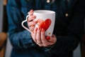 Woman holding cup with heart shape. Close up Royalty Free Stock Photo