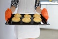 Woman holding hot roasting pan with hot, freshly baked bread rolls Royalty Free Stock Photo