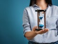 Woman holding hourglass on color background, closeup. Time management concept Royalty Free Stock Photo