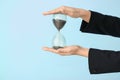 Woman holding hourglass on color background. Time management concept Royalty Free Stock Photo