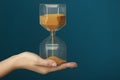 Woman holding hourglass on color background. Time management concept Royalty Free Stock Photo