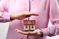 Woman holding house model and coins Royalty Free Stock Photo