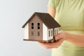 Woman holding house model on grey background, closeup. Mortgage concept Royalty Free Stock Photo