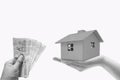 Woman holding house model on grey background. Mortgage concept Royalty Free Stock Photo