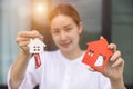 Woman holding a house model and house key. Property investment and house mortgage financial real estate concept Royalty Free Stock Photo