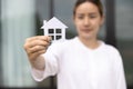 Woman holding a house model. Property investment and house mortgage financial real estate concept Royalty Free Stock Photo