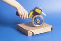 Woman holding an industrial tape dispenser,cardboard box sealing Royalty Free Stock Photo