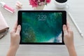 Woman holding iPad Pro Space Gray with wallpaper IOS 10
