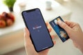 Woman holding iPhone X with payment system service Payoneer