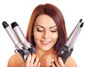 Woman holding iron curling hair.