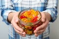 Woman holding jar of colorful jelly bears on light background Royalty Free Stock Photo