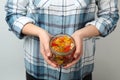 Woman holding jar of colorful jelly bears on light background