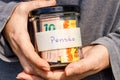 A woman holding a jar with retirement money in her hands, a handwritten inscription on the jar Retirement in Portuguese, Brazilian