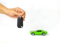 Woman holding key and automobile model on isolate white background Royalty Free Stock Photo