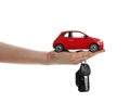 Woman holding key and miniature automobile model on background, closeup. Car buying Royalty Free Stock Photo