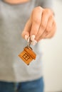 Woman holding key with trinket in shape of house, closeup Royalty Free Stock Photo