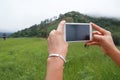 Woman holding landscape smartphone with blank screen while On the mountain Royalty Free Stock Photo