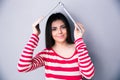 Woman holding a laptop above her head like a roof Royalty Free Stock Photo