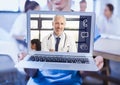 Woman holding a laptop with doctor on video call screen Royalty Free Stock Photo