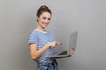 Woman holding laptop and pointing at screen, satisfied about computer application, internet news. Royalty Free Stock Photo