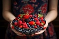 Woman holding large bowl of berries