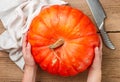 Woman holding a large whole organic pumpkin