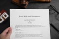 Woman holding last will and testament at black table, top view Royalty Free Stock Photo