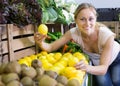 woman holding lemons in hands in fruit store Royalty Free Stock Photo