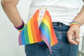 Woman holding LGBT rainbow colorful flag, symbol of lesbian, gay, bisexual, transgender, human rights, tolerance and peace