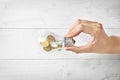 Woman holding light bulb on wooden background, closeup. Electricity saving concept