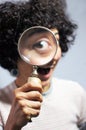 Woman holding and looking through a magnifier