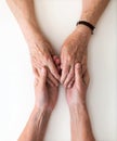 Nurse consoling her elderly patient by holding her hands