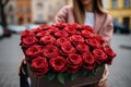 Woman holding luxury bouquet of fresh red roses