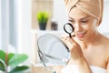 Woman holding magnifier and zoom damage on skin Royalty Free Stock Photo