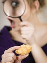 Woman holding magnifying glass investigating bread