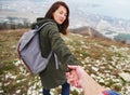 Woman holding man's hand and leading him outdoor