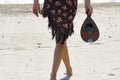 Woman holding a mandolin at the beach