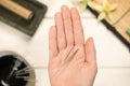 Woman holding many acupuncture needles over white wooden table, closeup Royalty Free Stock Photo