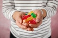Woman holding many colorful candies on color background Royalty Free Stock Photo
