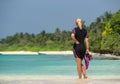 Woman holding mask and flippers for swimming on tropical beach Royalty Free Stock Photo