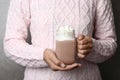 Woman holding mason jar of delicious cocoa drink with marshmallows